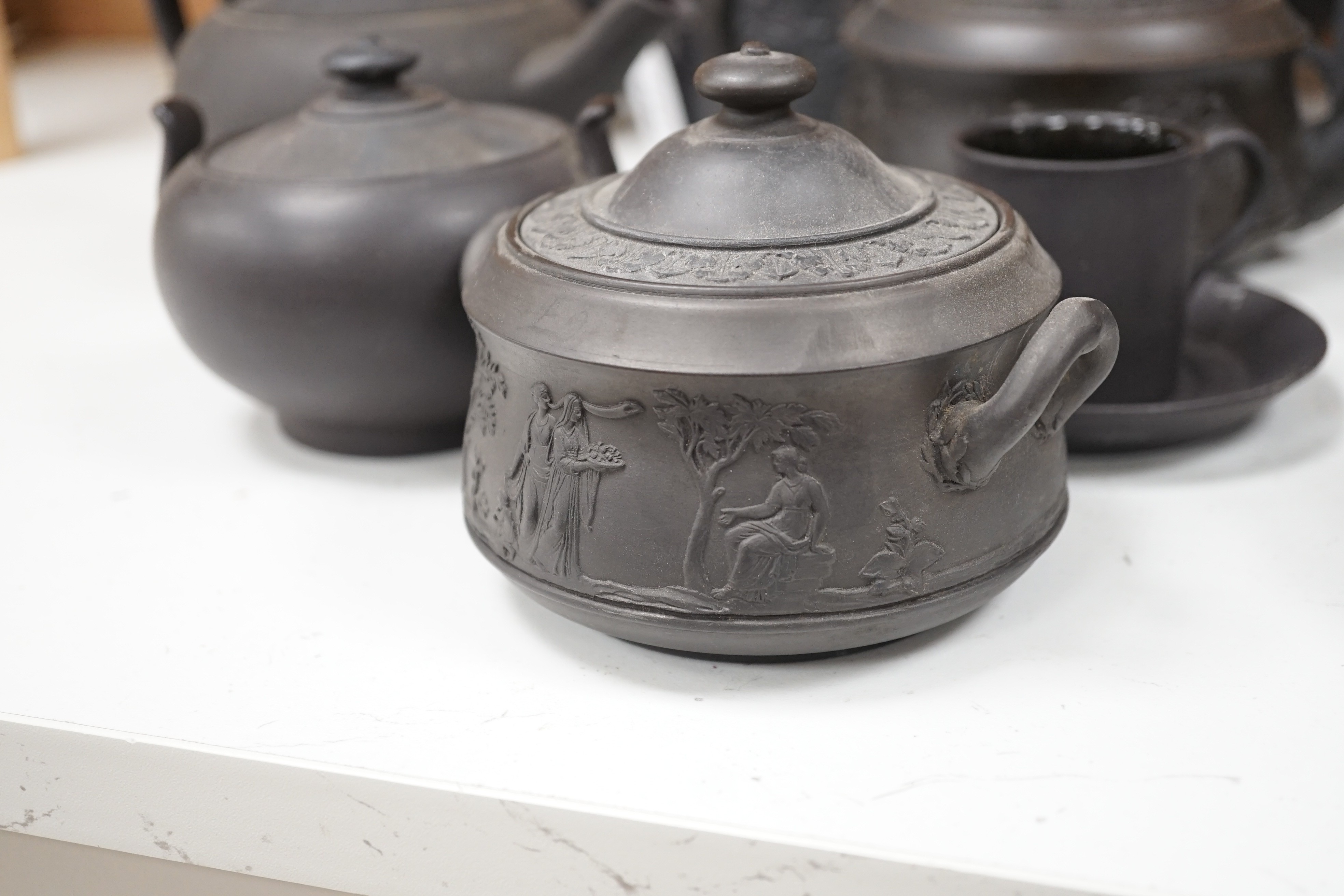 A collection of Wedgwood and other black basalt teapots and tea wares, 19th/early 20th century, tallest teapot 17cms high